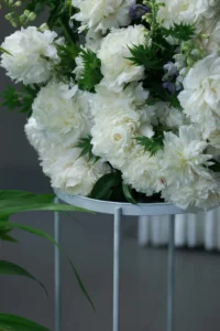 Grand bouquet composé de pivoines blanches pour cérémonie d'hommage.