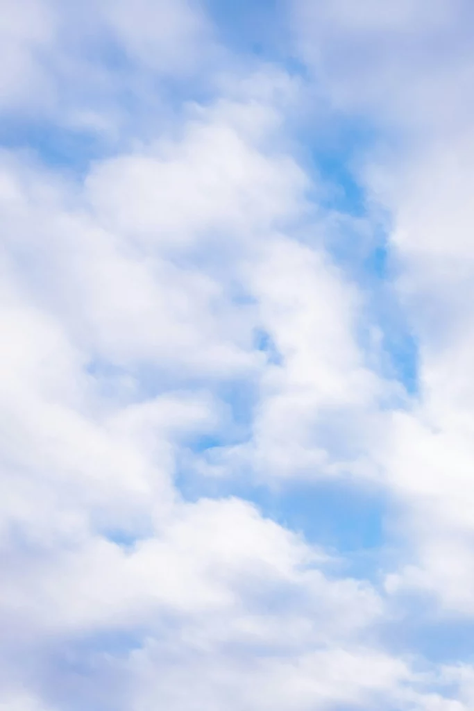 Ciel d'un bleu doux recouvert de nuages blancs cotonneux.